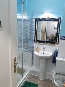 a bathroom with a sink and a shower with a mirror at Centro de Baracaldo, parcela de garaje gratis in Barakaldo