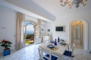 a dining room with a table and a view of the ocean at YourHome - Relais Casa degli Angeli in Positano