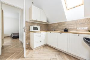 Una cocina blanca con fregadero y microondas. en Palanga Deluxe 2, en Palanga