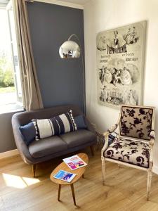 a living room with a couch and a chair at Hotel d'Angleterre Etretat in Étretat