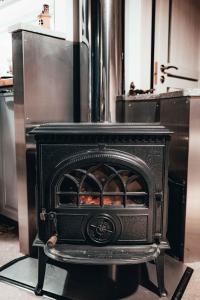 a black stove in a kitchen with a counter at Annas Dzirnavas in Annas