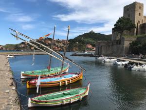 Trois bateaux sont amarrés dans l'eau près d'un château dans l'établissement Les Chênes-lièges d'Ambeille, à Collioure