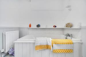 wanna z żółtym i białym ręcznikiem w obiekcie Luxury Accommodation with Games Room - Sleeps 10 w mieście Rathmullan