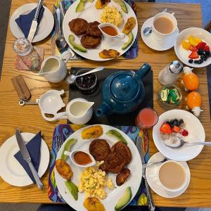 una mesa de madera cubierta con platos de desayuno en Archway Guest House, en Windermere