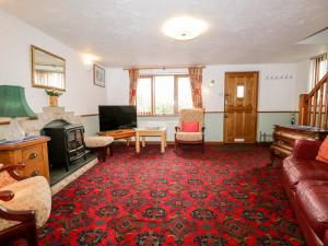 een woonkamer met een bank en een televisie bij Rose Cottage in Kendal