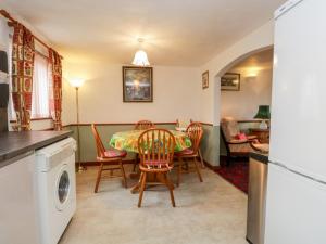 een keuken en eetkamer met een tafel en stoelen bij Rose Cottage in Kendal