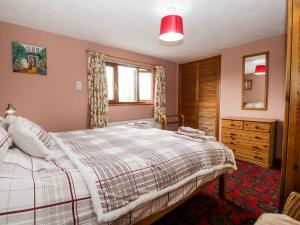 een slaapkamer met een bed en een ladekast bij Rose Cottage in Kendal