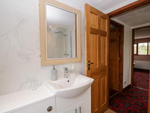 een witte badkamer met een wastafel en een spiegel bij Rose Cottage in Kendal +20 foto's
