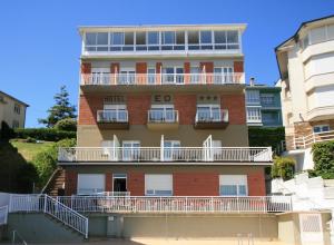 un edificio de ladrillo rojo con balcones blancos en Hotel EO en Ribadeo