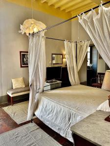 1 dormitorio con cama con dosel y sofá en Villa I Bossi, en Arezzo