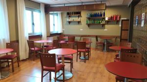 una sala da pranzo con tavoli e sedie rossi di Hotel EO a Ribadeo