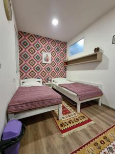 um quarto com 2 camas e uma parede com papel de parede em Apartment Music em Sarajevo