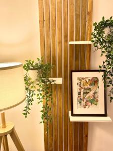 a picture on a wall with two plants and a lamp at Atrium Boutique in Naples