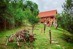 a log cabin with a pile of wood in front of it at Heaven Treehouse - ADULT ONLY RESORT, SELF CHECK IN in Peşteana