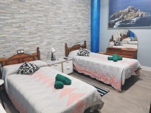 a bedroom with two beds and a brick wall at Centro de Baracaldo, parcela de garaje gratis in Barakaldo