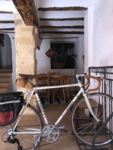 una bicicleta estacionada frente a una casa con un perro en El Cap de Pedra en La Cuevarruz