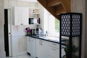 a kitchen with white cabinets and a sink and a window at Duplex, 2 Sdb, 2 chambres, dans une impasse en centre-ville in Gérardmer
