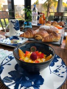 un bol de fruta en una mesa con bollería y pan en Les Suites Champenoises en Reims