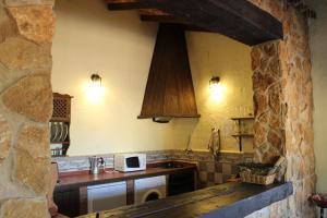 cocina con fregadero y encimera con microondas en Casas Rurales Las Cuevas El Rincón, en Fuentes de León