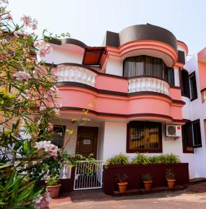 a pink and white house with plants in front of it at 'Golden Oceans' 3 bhk beach view villa in Benaulim