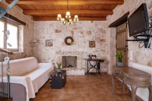 a living room with a couch and a fireplace at Strofilia Authentic Villas in Skinária