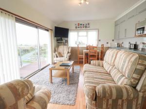 uma sala de estar com dois sofás e uma mesa em Morlyn Guest House Apartment em Harlech