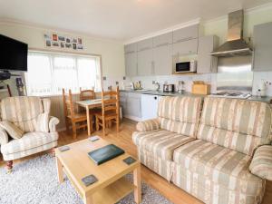 een woonkamer met een bank en een tafel bij Morlyn Guest House Apartment in Harlech