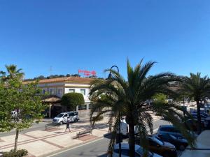 un parking avec des palmiers en face d'un bâtiment dans l'établissement Cala del Mar Apartment - La Cala de Mijas, à La Cala de Mijas