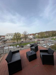 ノインキルヒェンにあるL1 Apartmentsの黒い家具付きのバルコニーから市街の景色を望めます。