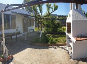 un cortile con panchina e una casa di Cosy home with private parking near by sea a Siniscola