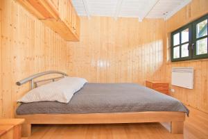 1 dormitorio con 1 cama en una pared de madera en Domek przy stoku en Lądek-Zdrój