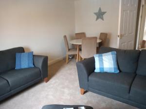 Sala de estar con 2 sofás y mesa en The Eaves, Glastonbury High Street, en Glastonbury
