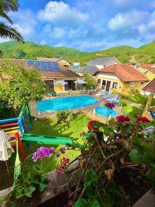 a backyard with a swimming pool and some flowers at Pousada Jardim Porto Belo in Porto Belo