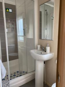 La salle de bains est pourvue d'un lavabo et d'une douche. dans l'établissement Prestige caravan,Seton Sands holiday village, WiFi, à Port Seton