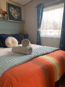 a bedroom with a bed with towels on it at Prestige caravan,Seton Sands holiday village, WiFi in Port Seton +38 photos