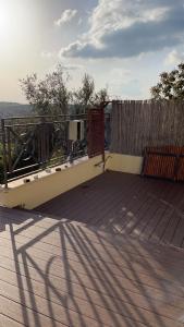 a wooden deck with a gate and a fence at La Villa Toscana: Pool & Elah Valley vineyard view in Adderet