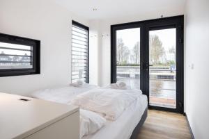 2 Betten in einem Zimmer mit Fenster in der Unterkunft Houseboat 'de Valreep' met tuin - Sneek - Offingawier in Offingawier