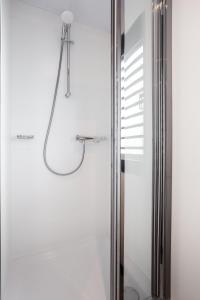 a shower with a shower head in a bathroom at Welcome in - Houseboat 'de Valreep' met tuin - Sneek - Offingawier in Offingawier