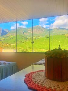 a room with a table with a view of a mountain at Estalagem e Restaurante Cantinho Bistrô in Alto Caparao