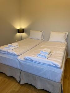 ソポトにあるPrzy Monciaku - Monte Cassino by OneApartmentsのベッド(白いシーツ、タオル付)