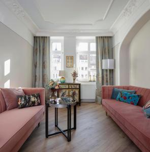 uma sala de estar com dois sofás cor-de-rosa e uma mesa em Design-Appartement im Herzen von Görlitz em Görlitz