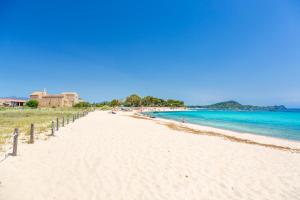a beach with people sitting on the sand and the water at Appartamento L’Angelica in Assemini