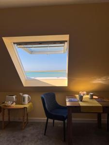 a window in a room with a table and a chair at Vallay Sands in Sollas