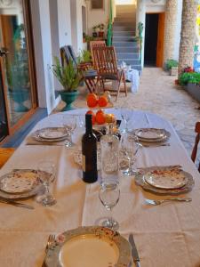 a table with plates and glasses and a bottle of wine at Holiday Home Kotulin in Pakoštane