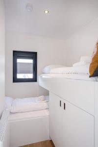 een kamer met 3 stapelbedden en een raam bij Houseboat Agua Dolce met tuin, Paviljoenwei 4, Sneek - Offingawier in Offingawier