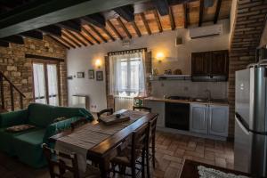 una cucina con tavolo in legno e divano verde di Bio Agriturismo Montemenardo Apartments a Todi