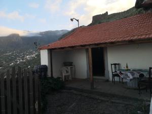 a white house with a table and a view of a mountain at La Cueva Refugio in Las Palmas de Gran Canaria