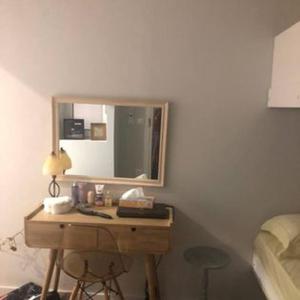 een slaapkamer met een bureau met een spiegel en een bed bij Sweet home in Póros