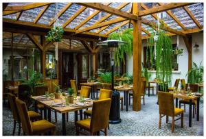 a restaurant with wooden tables and chairs with plants at Folwark Walencja in Kazimierz Dolny