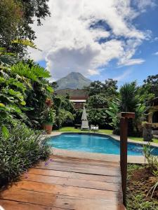 a swimming pool in a garden with a mountain in the background at Hotel Arte Natura in Fortuna